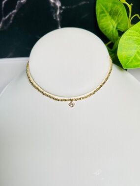 Delicate gold beaded choker necklace featuring a small sparkling CZ clover